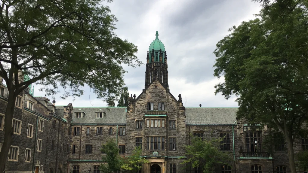 Historic stone university building with a green quad in Canada