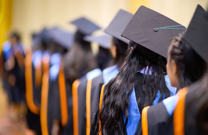 Graduates in caps and gowns lined up at a graduation ceremony